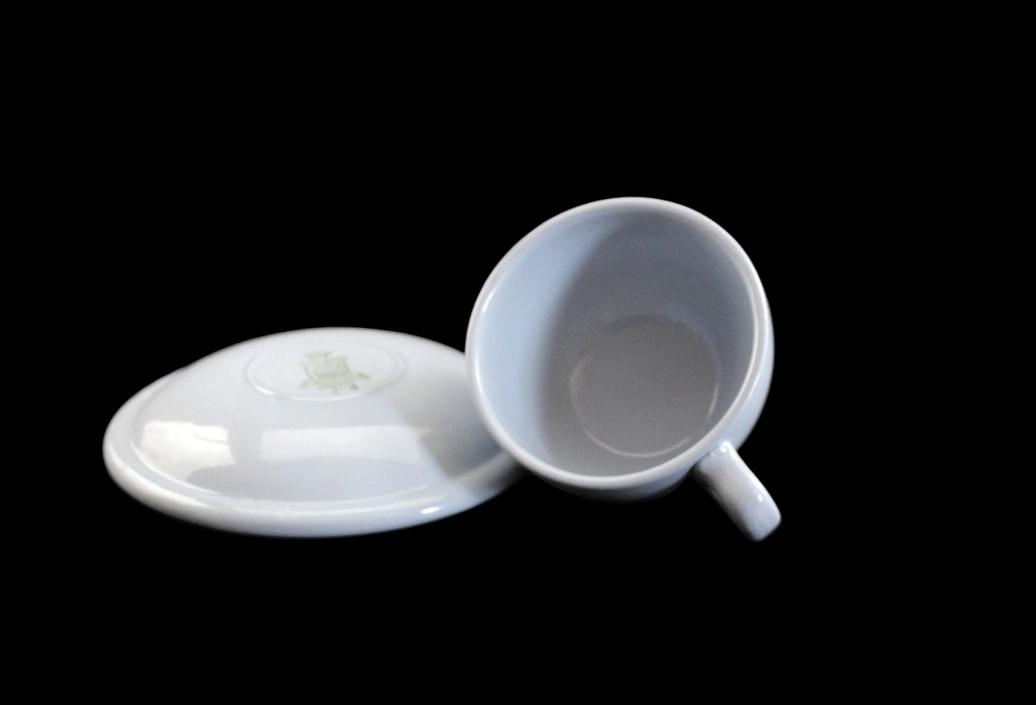 Light blue ceramic cup and saucer on a dark background