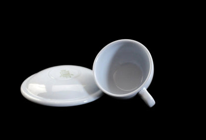 Light blue ceramic cup and saucer on a dark background
