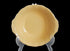 Yellow ceramic bowl on a clear stand against a dark background