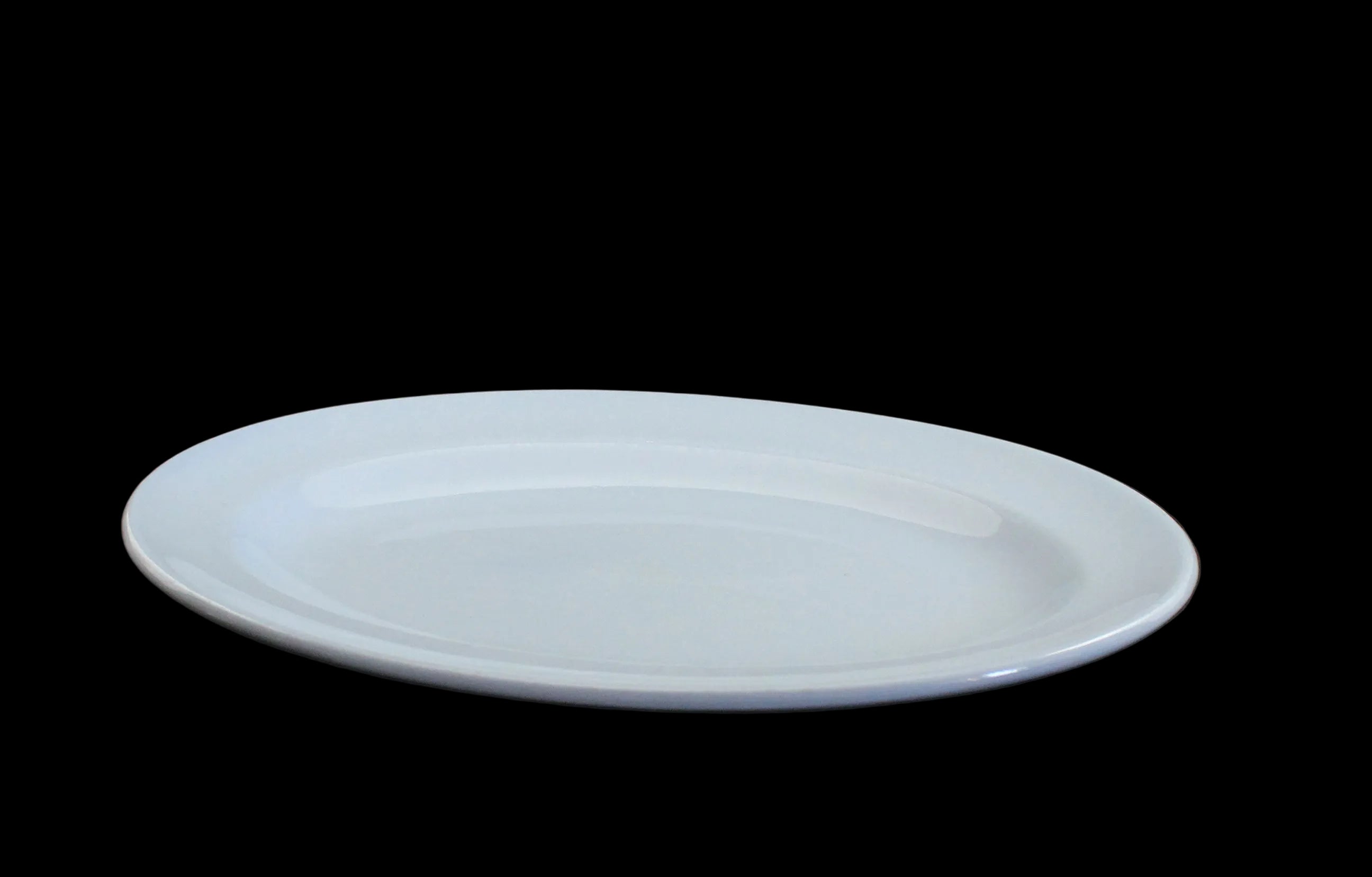 A blue ceramic oval serving platter with a shallow center, shown on a dark gray background.