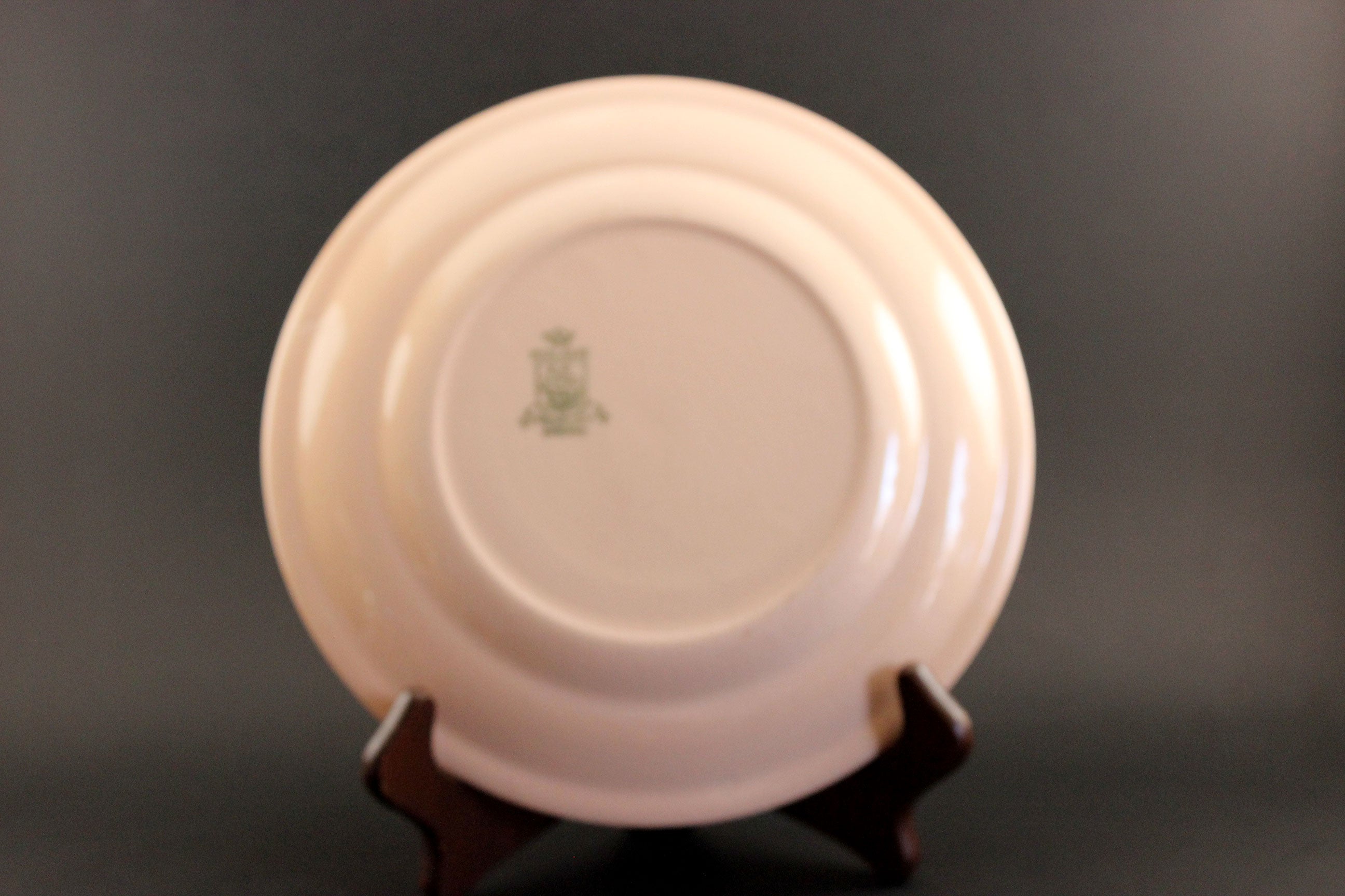 Pink ceramic plate with a logo on a dark background