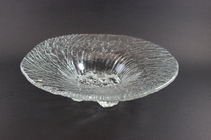 Clear glass bowl with textured surface on a dark background