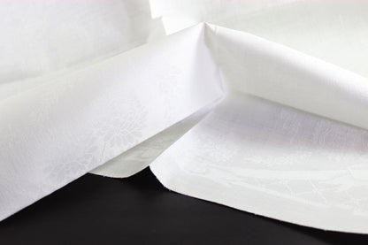 Close-up of white damask linen napkin with a subtle pattern