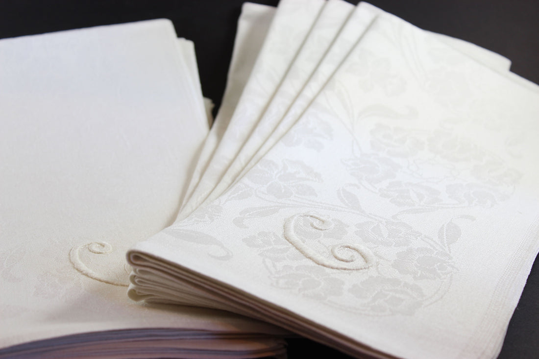 Irish Linen napkins with embroidered monogram. Roses and Daffodil design. Black background.