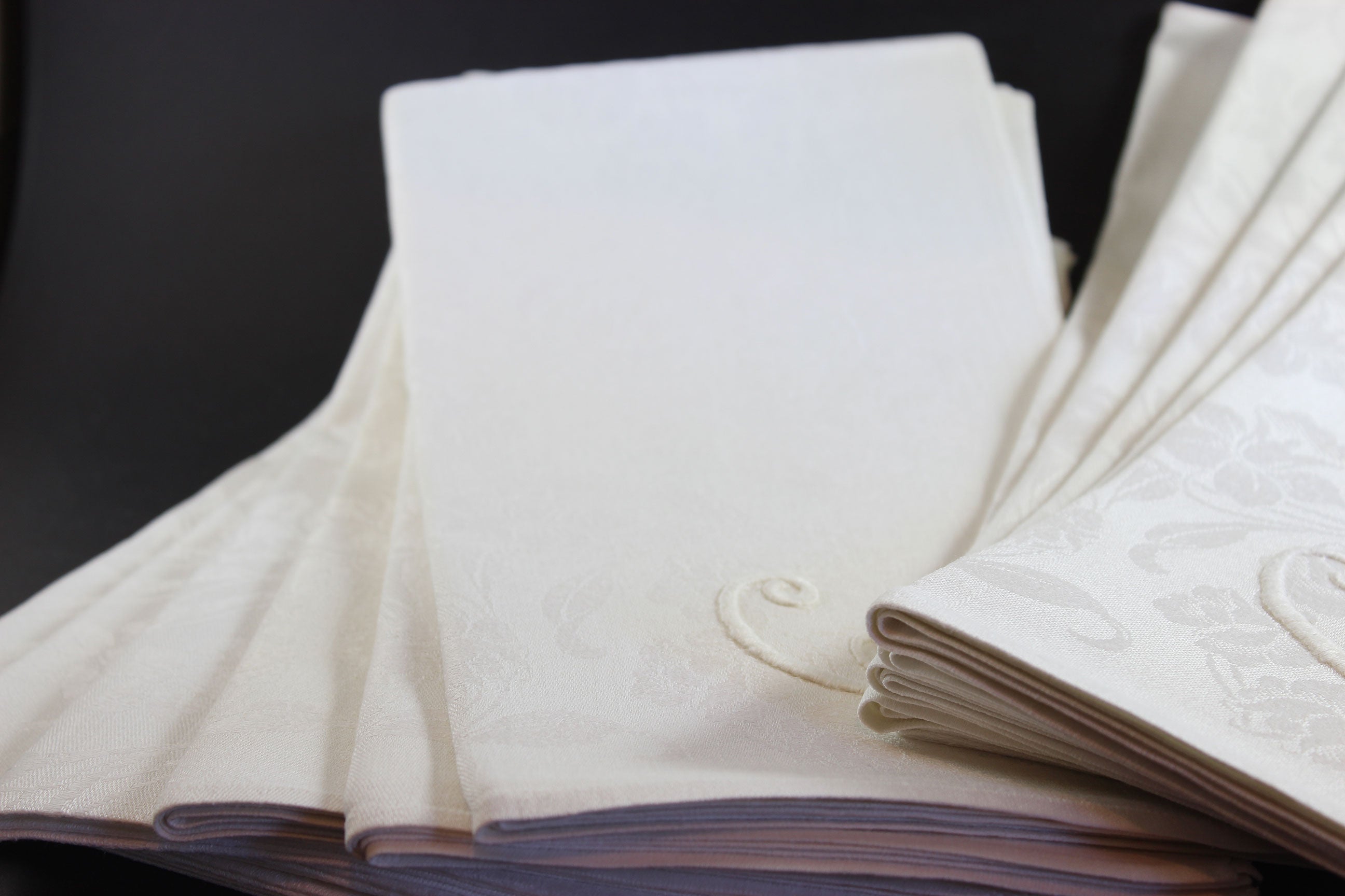 Irish Linen napkins with embroidered monogram. Roses and Daffodil design. Black background.