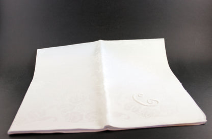 Irish Linen napkins with embroidered monogram. Roses and Daffodil design. Black background.