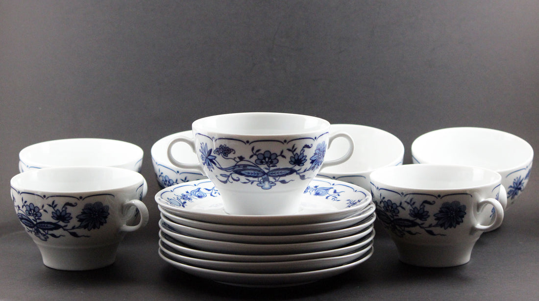 Set of white porcelain soup bowls with blue floral patterns on a gray background