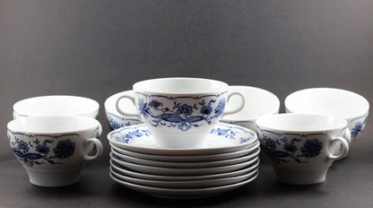 Set of white porcelain soup bowls with blue floral patterns on a gray background