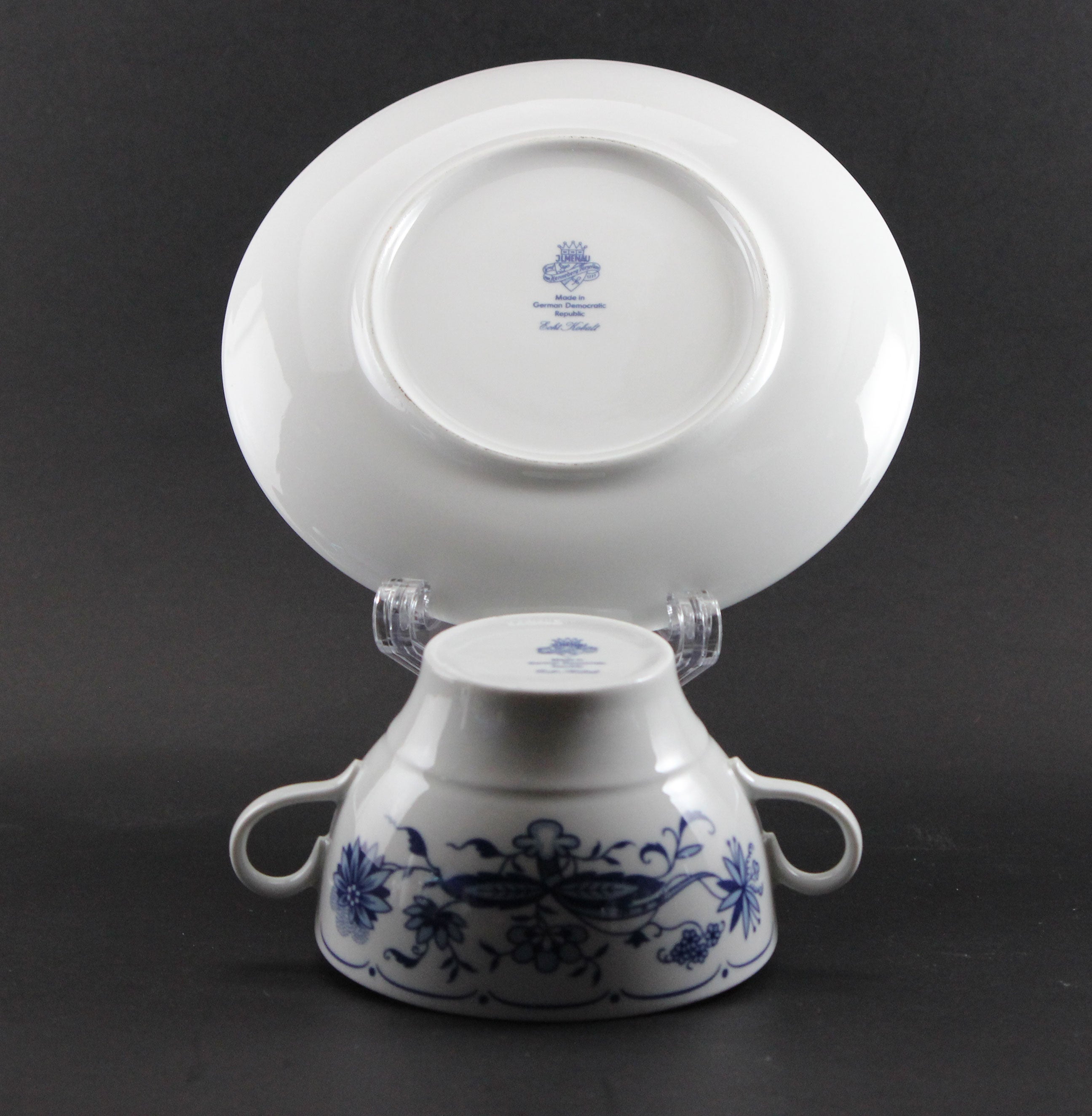 Set of white porcelain soup bowls with blue floral patterns on a gray background