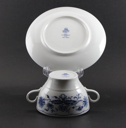 Set of white porcelain soup bowls with blue floral patterns on a gray background