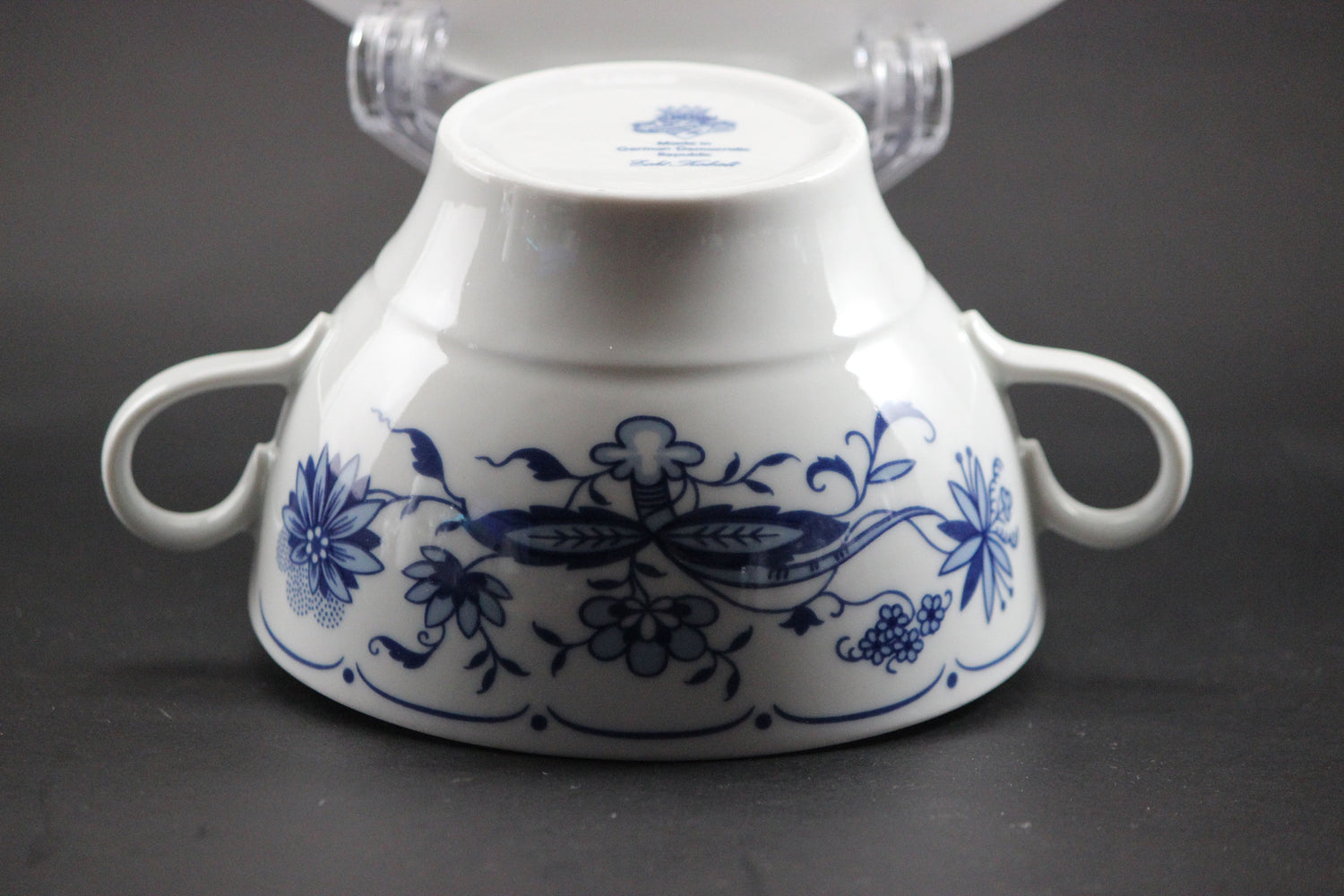 Set of white porcelain soup bowls with blue floral patterns on a gray background