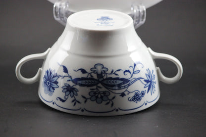 Set of white porcelain soup bowls with blue floral patterns on a gray background
