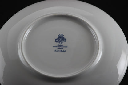 Set of white porcelain soup bowls with blue floral patterns on a gray background