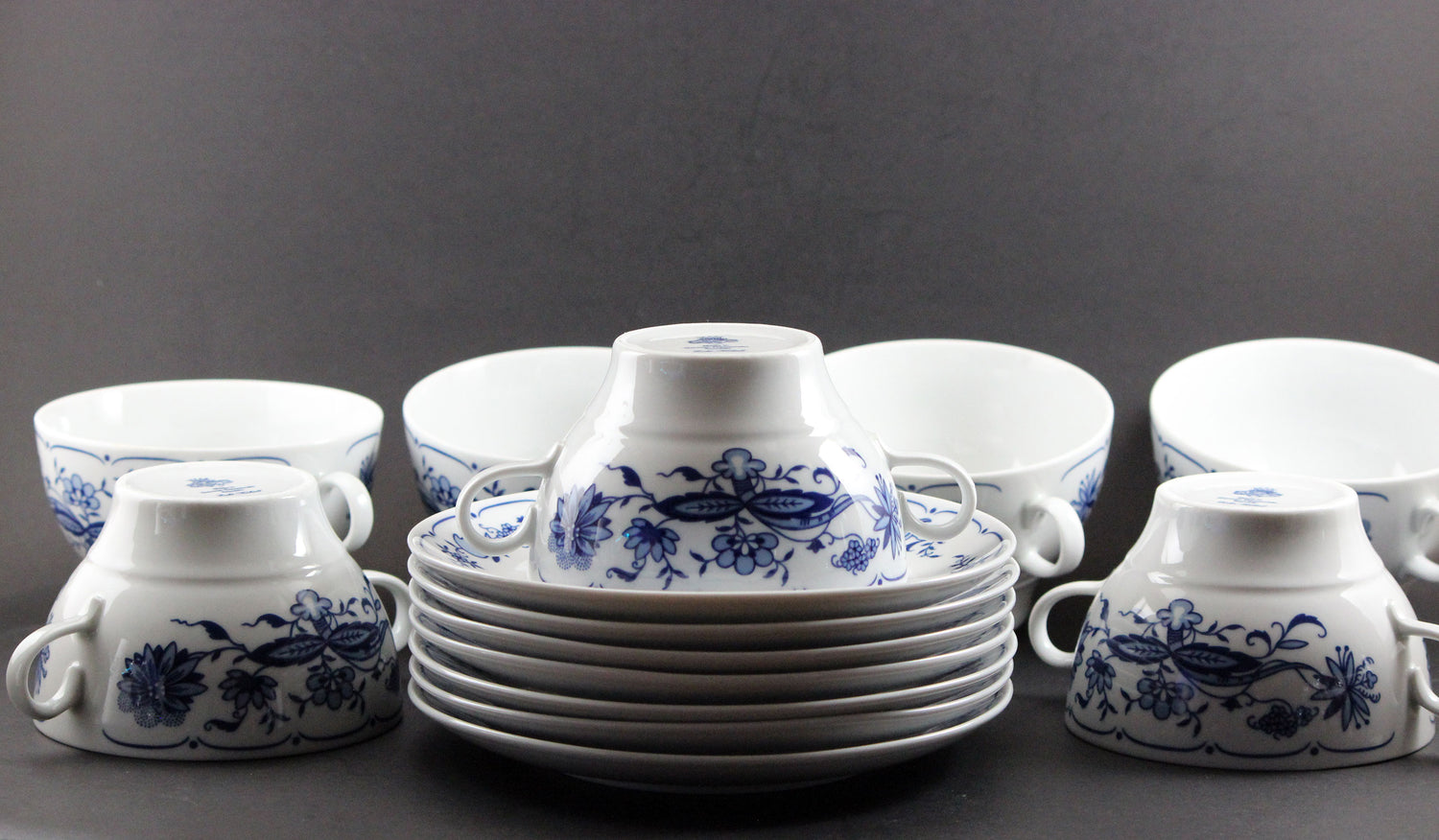 Set of white porcelain soup  bowls with blue floral patterns on a gray background