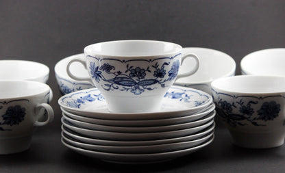 Set of white porcelain soup bowls with blue floral patterns on a gray background