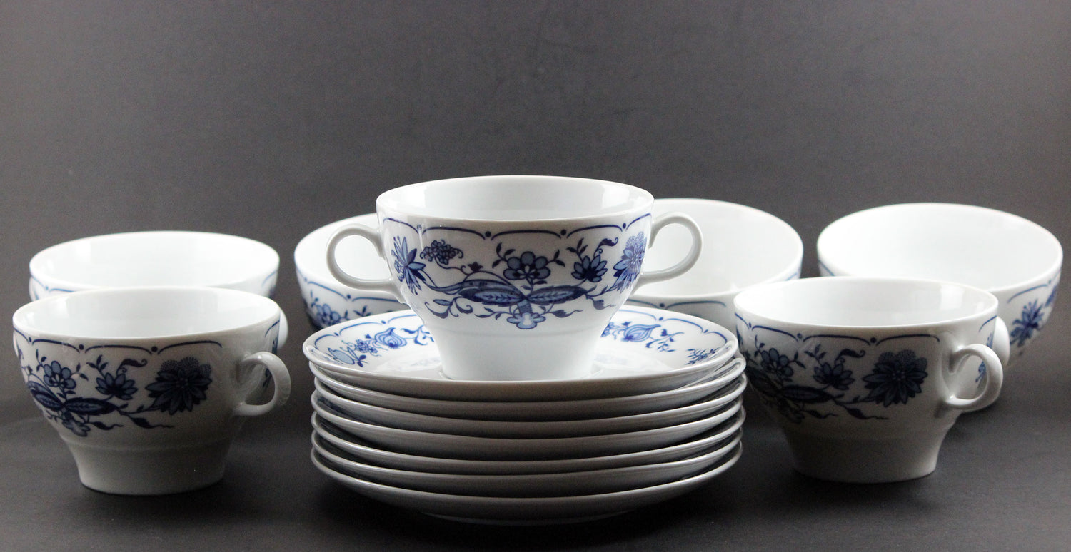 Set of white porcelain soup bowls with blue floral patterns on a gray background