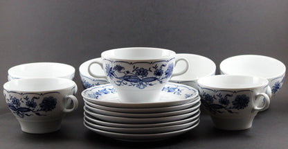 Set of white porcelain soup bowls with blue floral patterns on a gray background