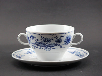 Set of white porcelain soup bowls with blue floral patterns on a gray background