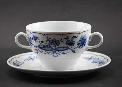 Set of white porcelain soup bowls with blue floral patterns on a gray background
