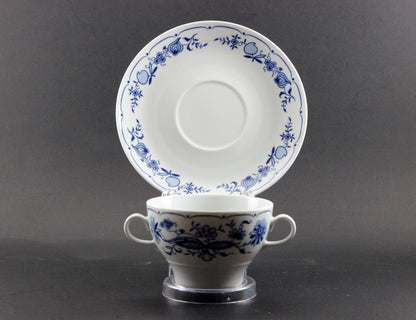 Set of white porcelain soup bowls with blue floral patterns on a gray background