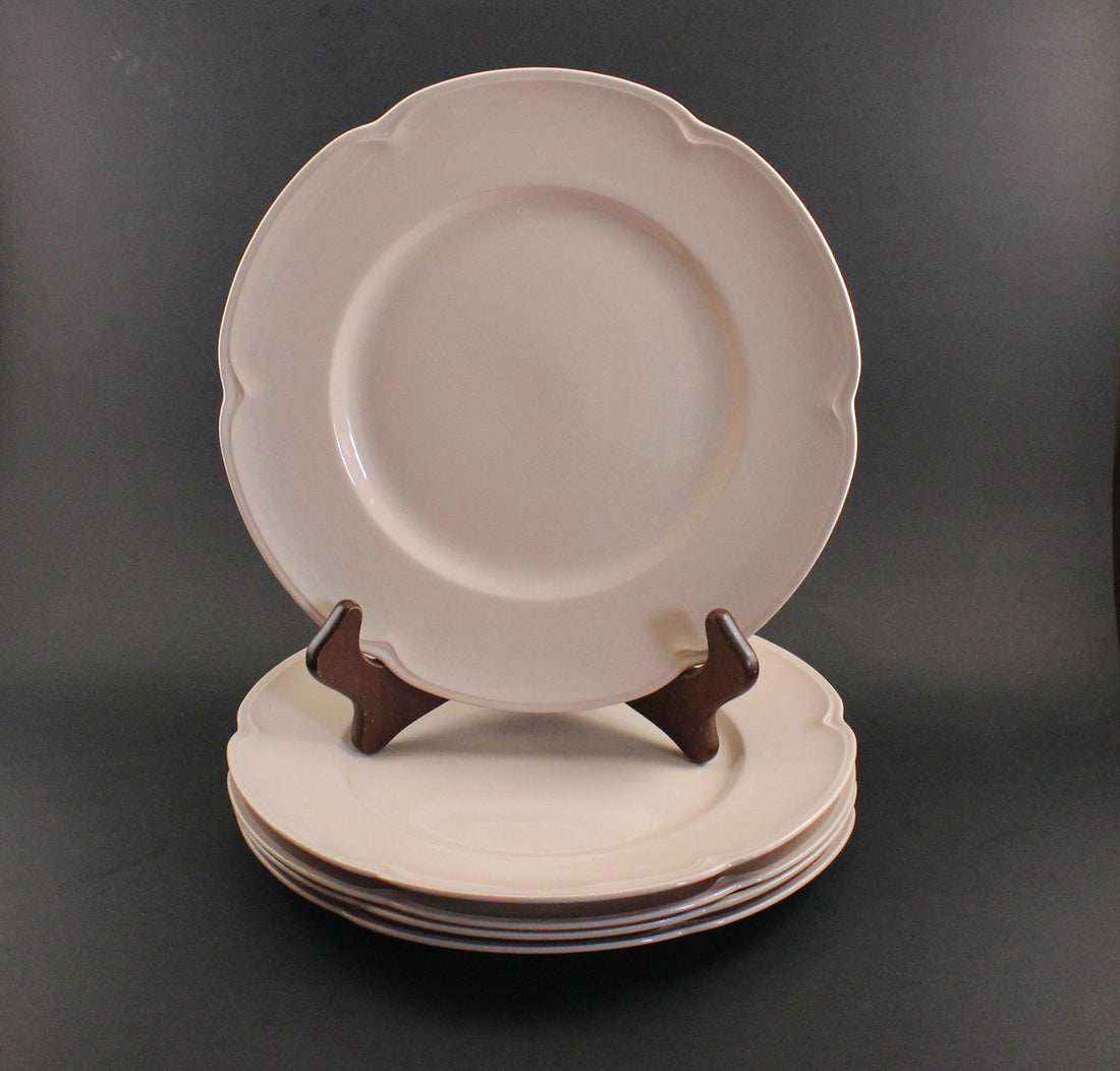 Set of pink ceramic petalware plates on a dark gray background