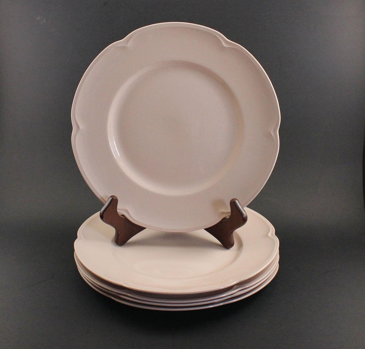 Set of pink ceramic petalware plates on a dark gray background