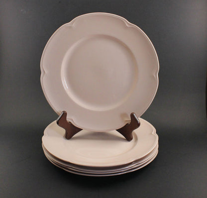 Set of pink ceramic petalware plates on a dark gray background