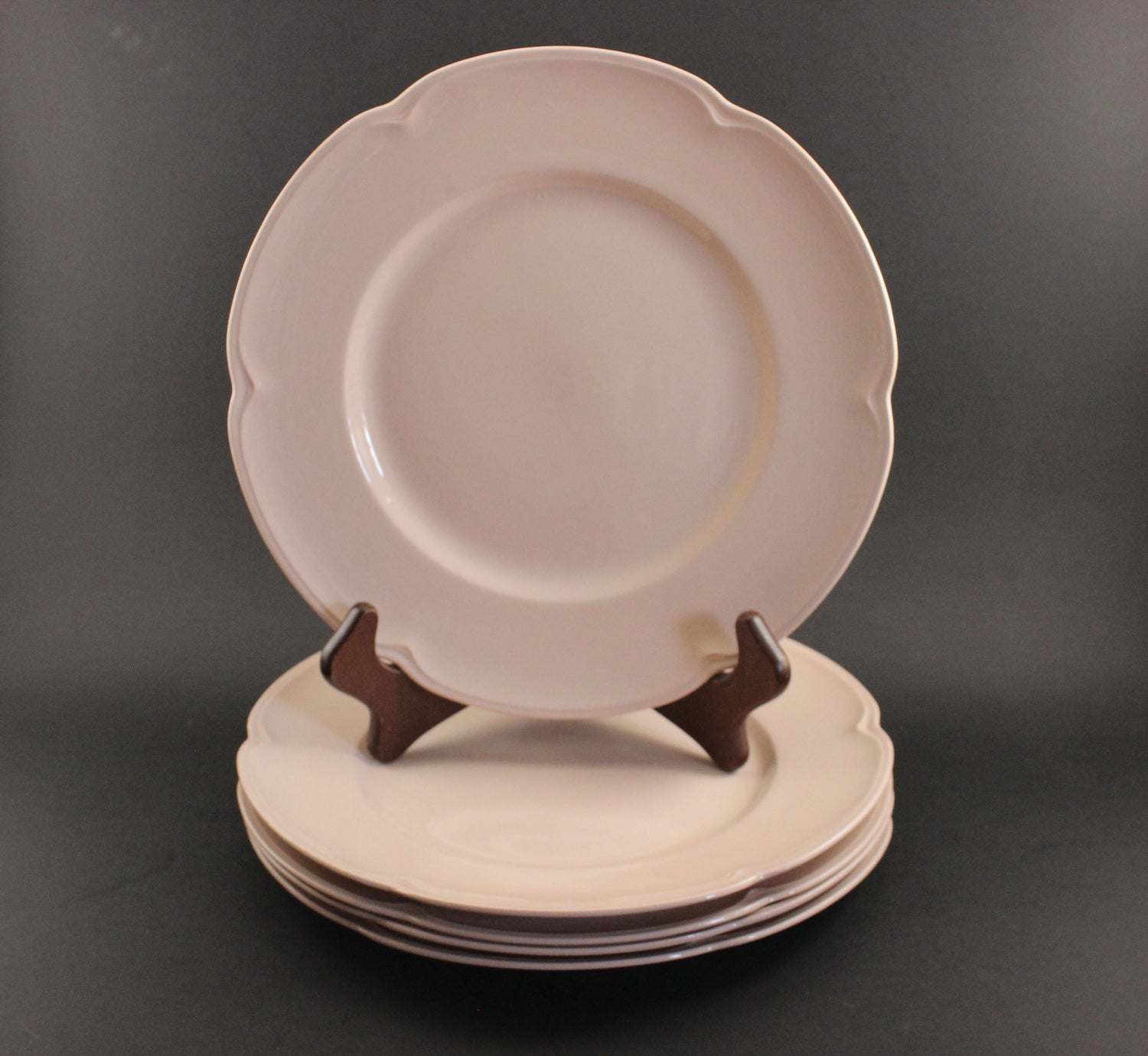 Set of pink ceramic petalware plates on a dark gray background