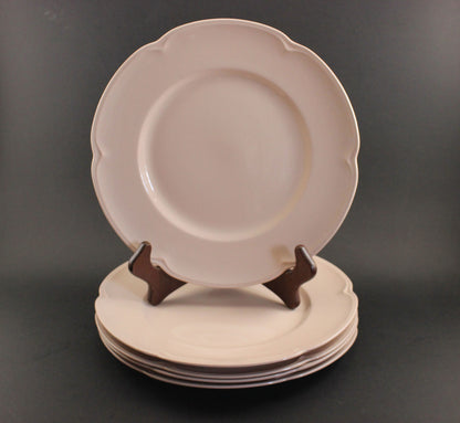 Set of pink ceramic petalware plates on a dark gray background