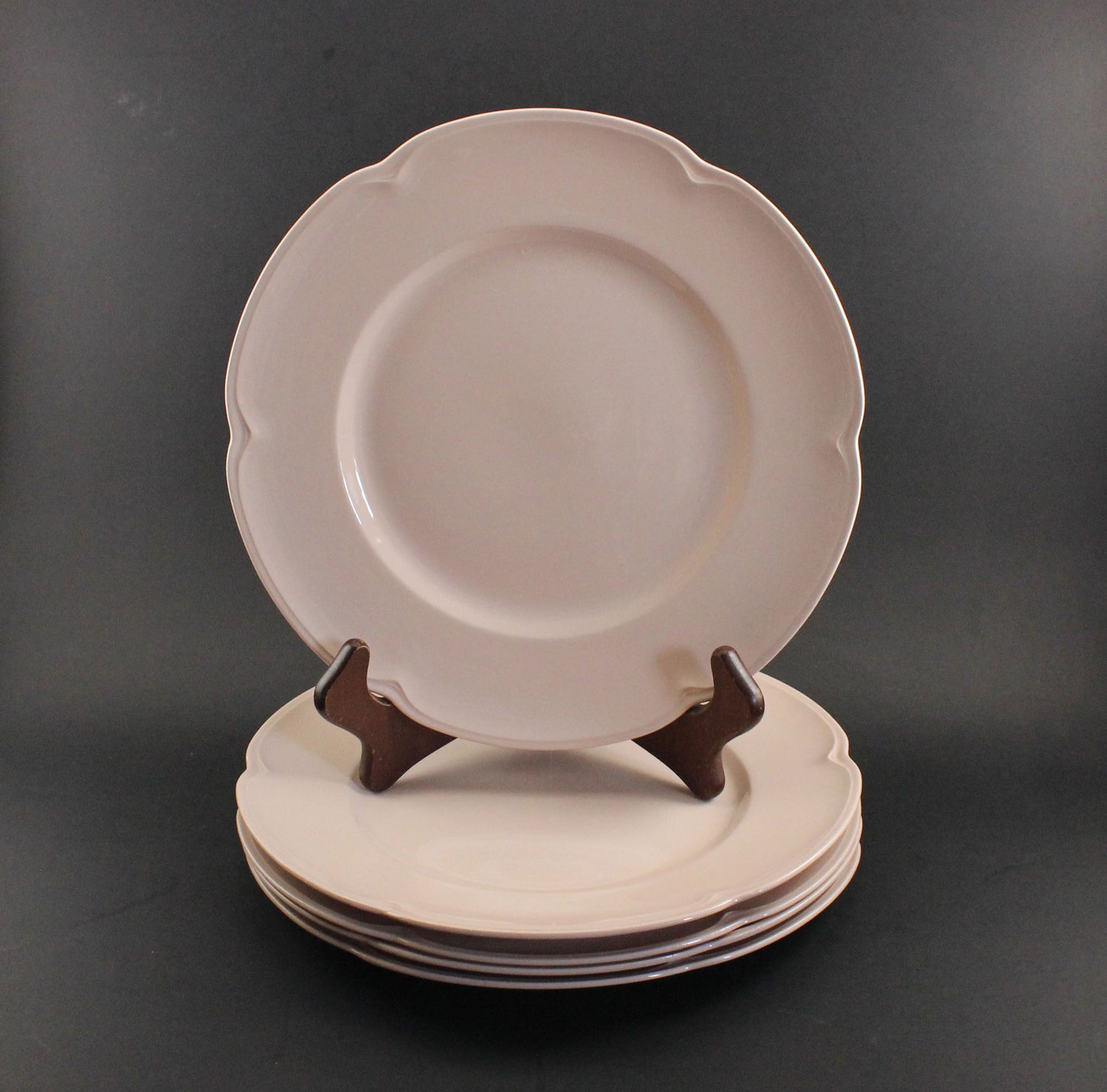 Set of pink ceramic petalware plates on a dark gray background