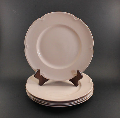 Set of pink ceramic petalware plates on a dark gray background