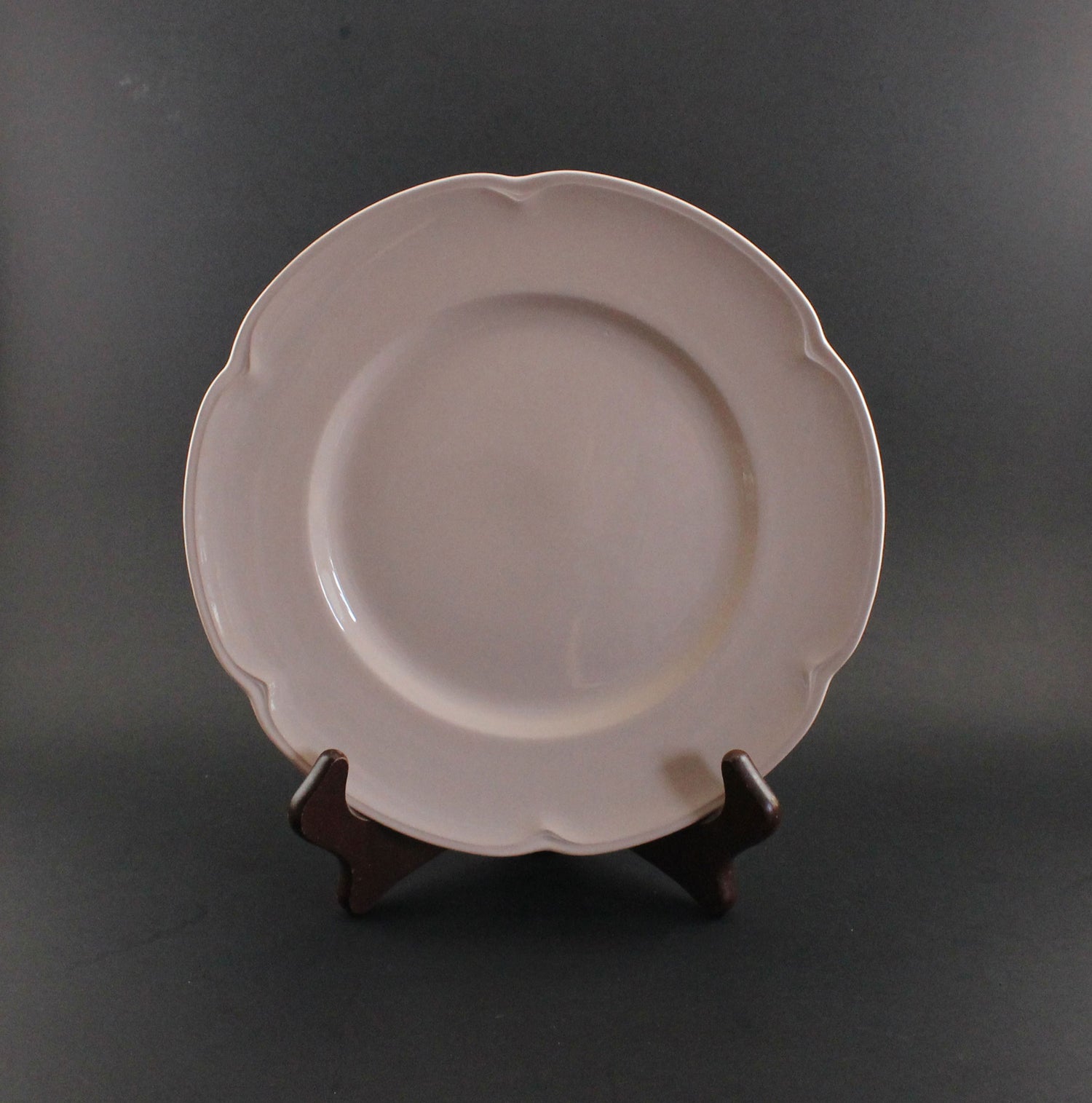 Pink ceramic petalware plate on a dark gray background