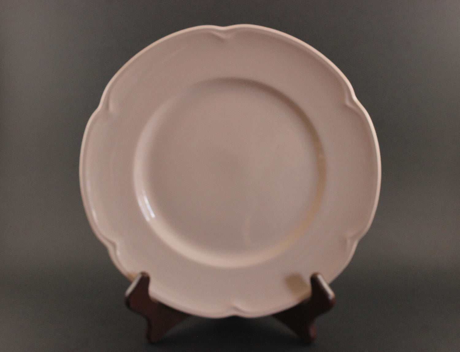 Pink ceramic petalware plate on a dark gray background