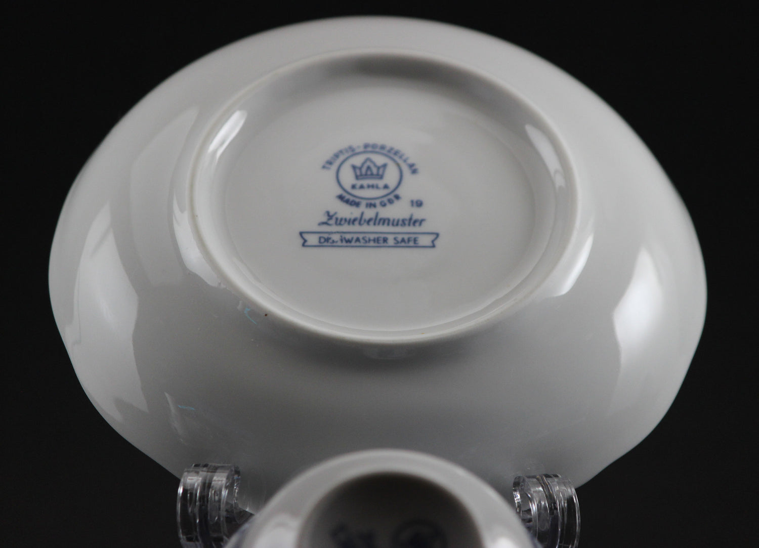 Porcelain teacup and saucer with blue floral patterns on a dark background