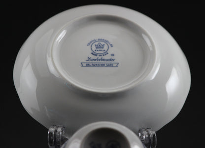 Porcelain teacup and saucer with blue floral patterns on a dark background