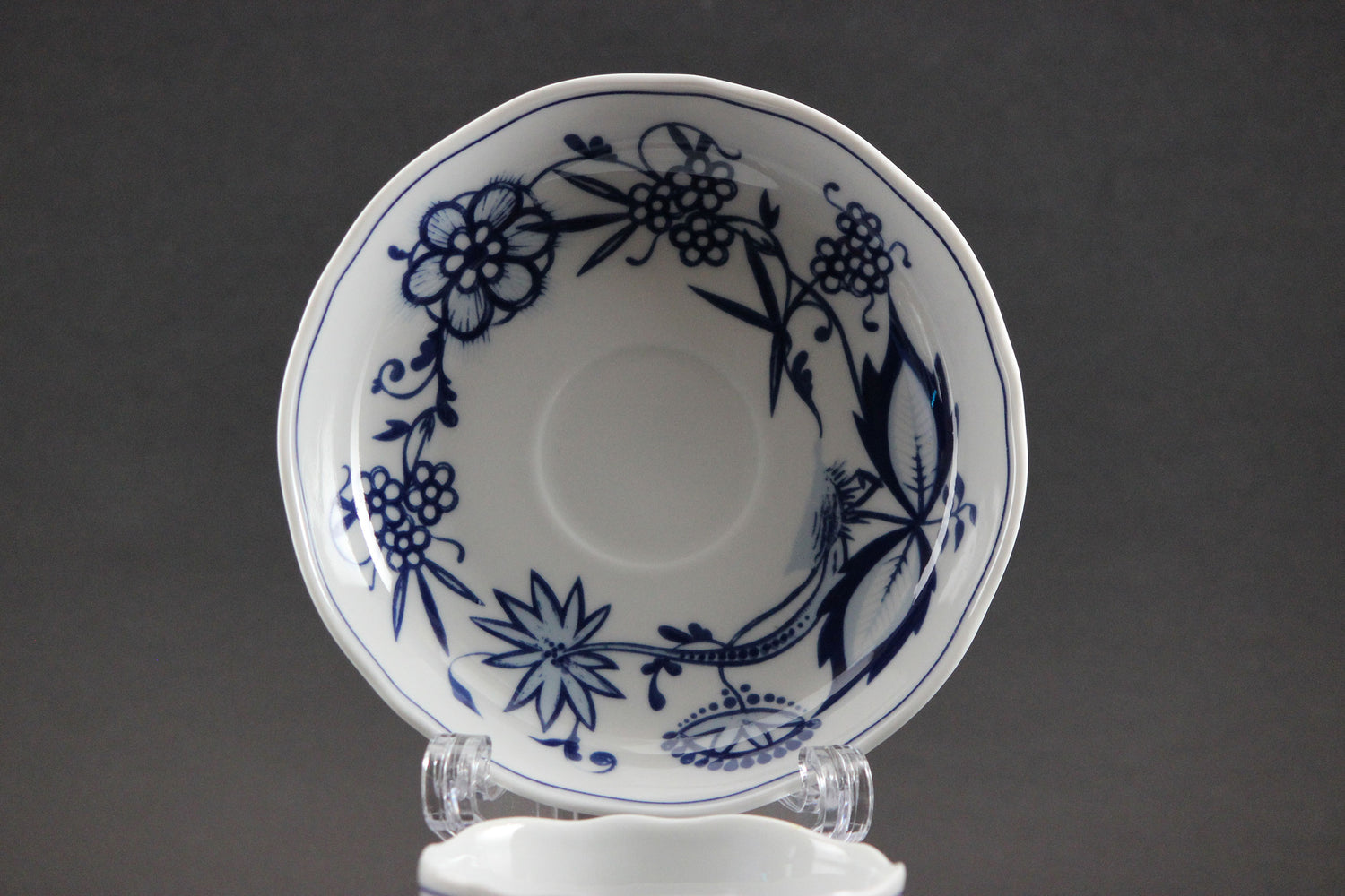 White saucer with blue floral patterns on a gray background