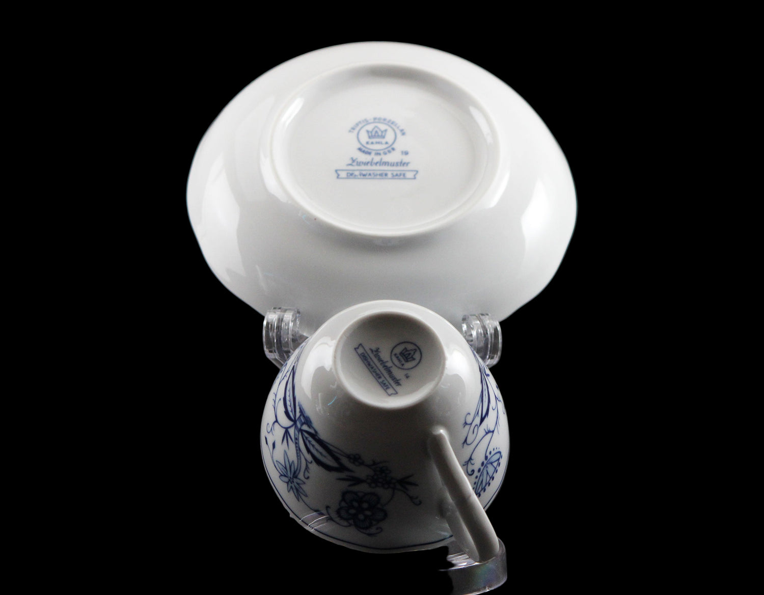 Porcelain teacup and saucer with blue floral patterns on a black background