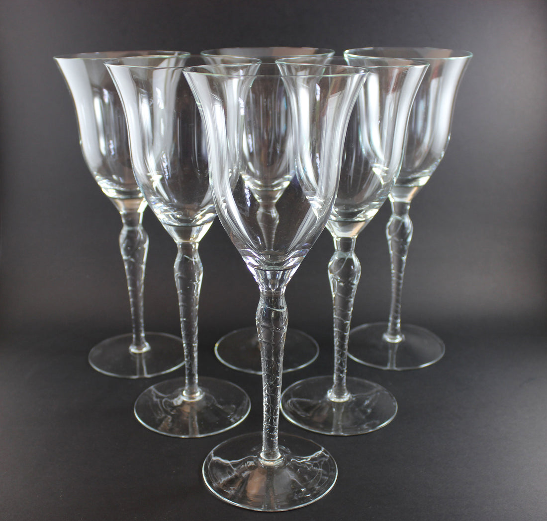 Set of six clear wine glasses on a dark background