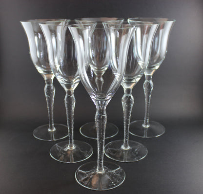 Set of six clear wine glasses on a dark background