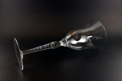 Clear glass wine glass with a long stem on a black background