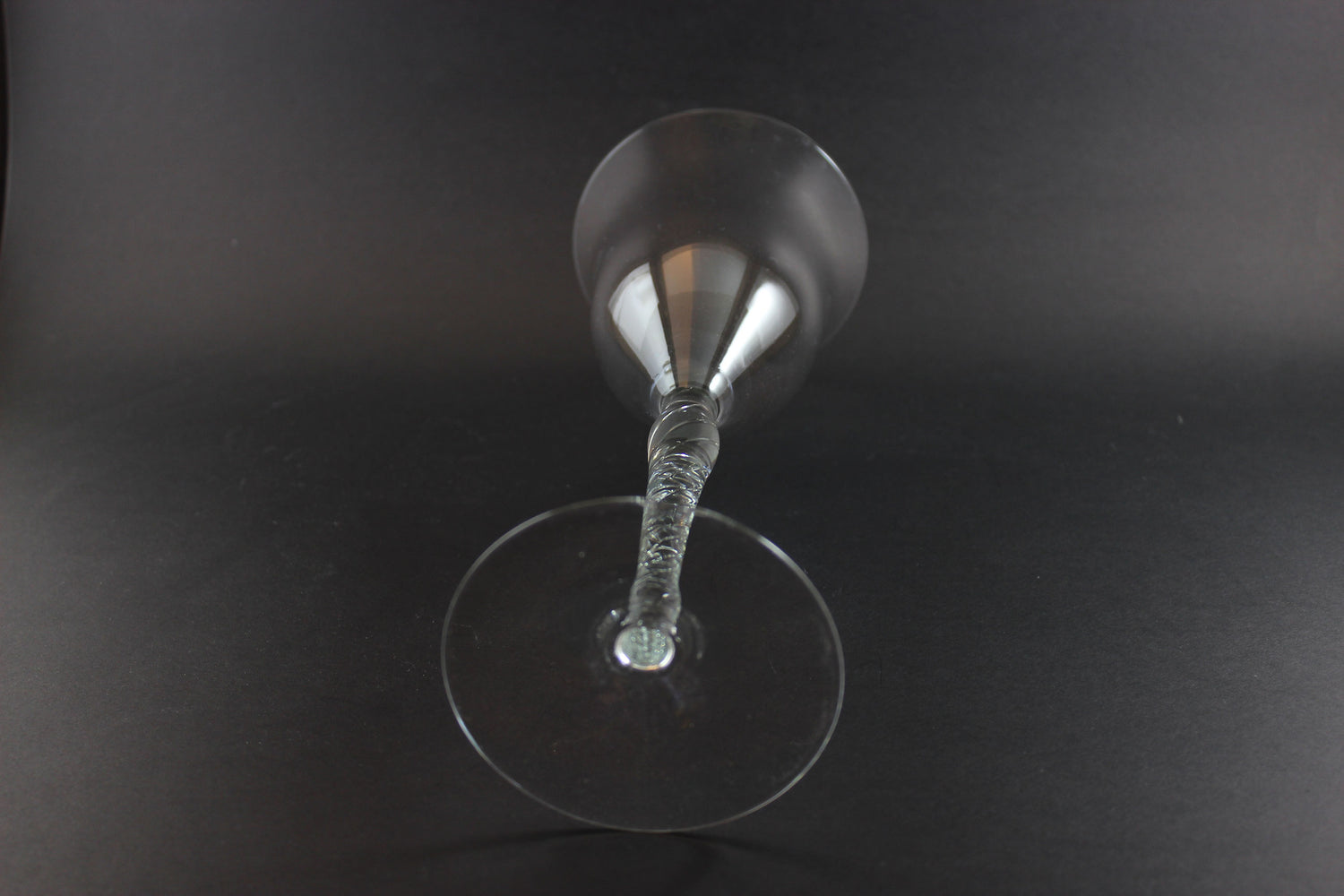 Clear glass with a textured stem on a black background