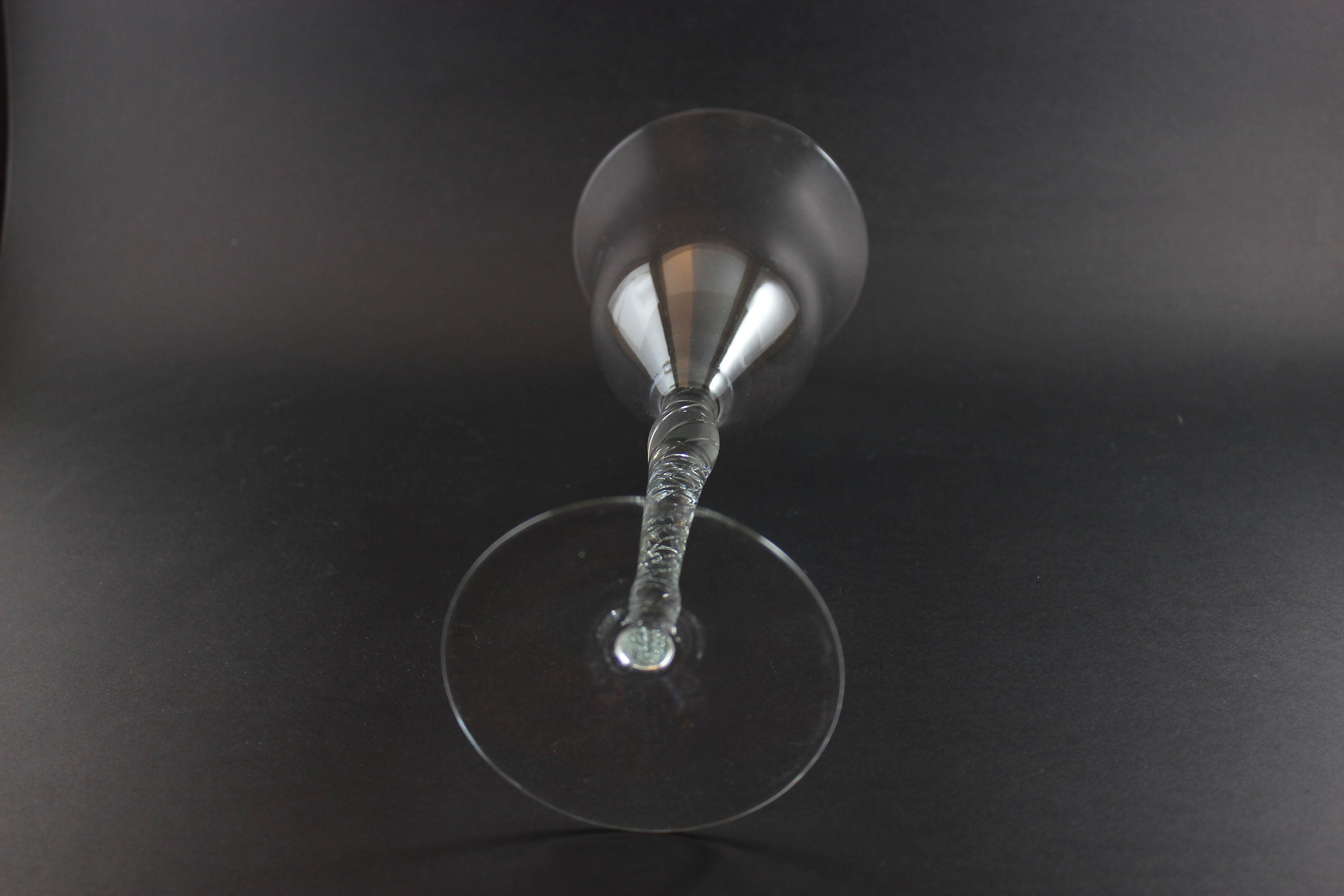 Clear glass with a textured stem on a black background