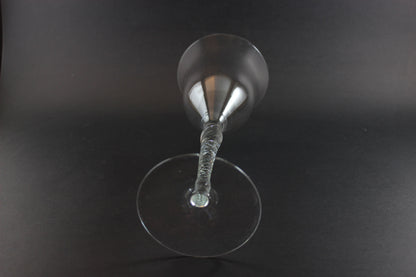 Clear glass with a textured stem on a black background