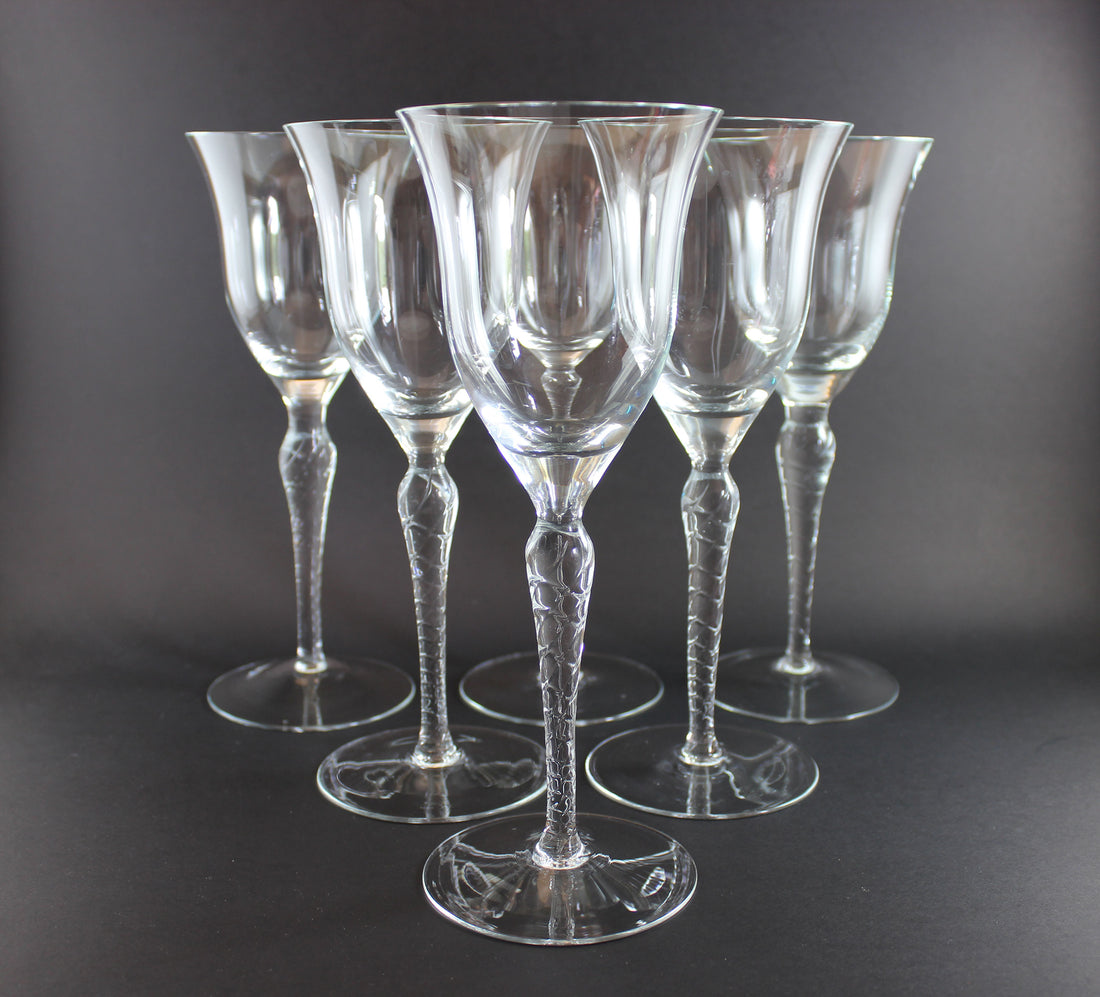 Set of six clear glass wine glasses on a dark background