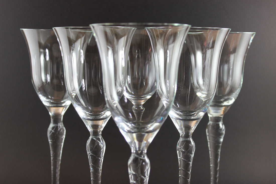 Set of six clear wine glasses on a dark background