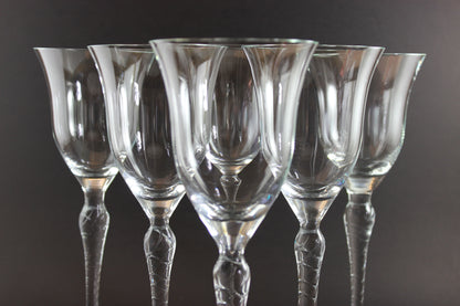 Set of six clear wine glasses on a dark background