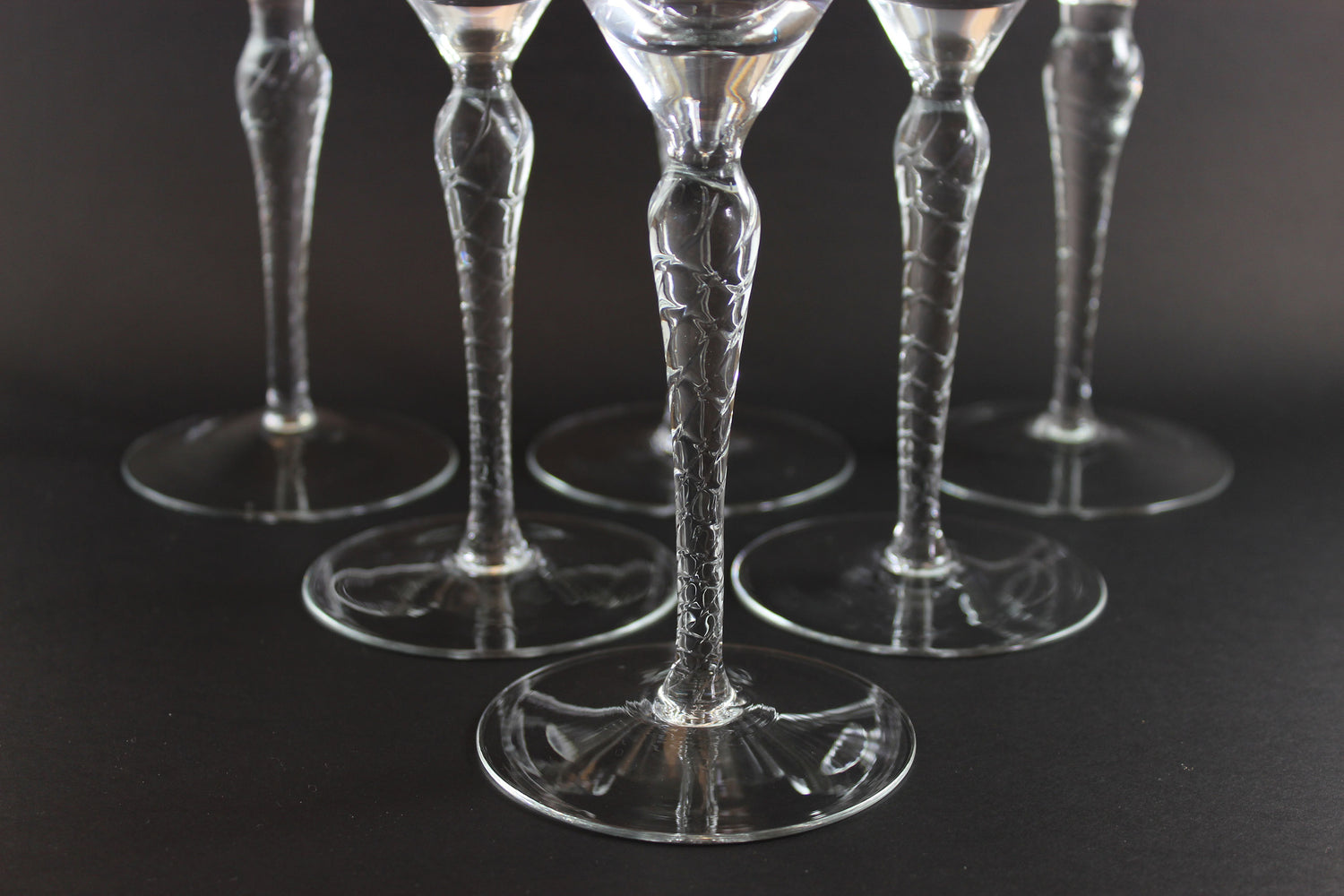 Set of clear glass goblets on a dark background