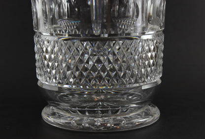 Close-up of a clear crystal bowl or vase with diamond cut pattern on a black background