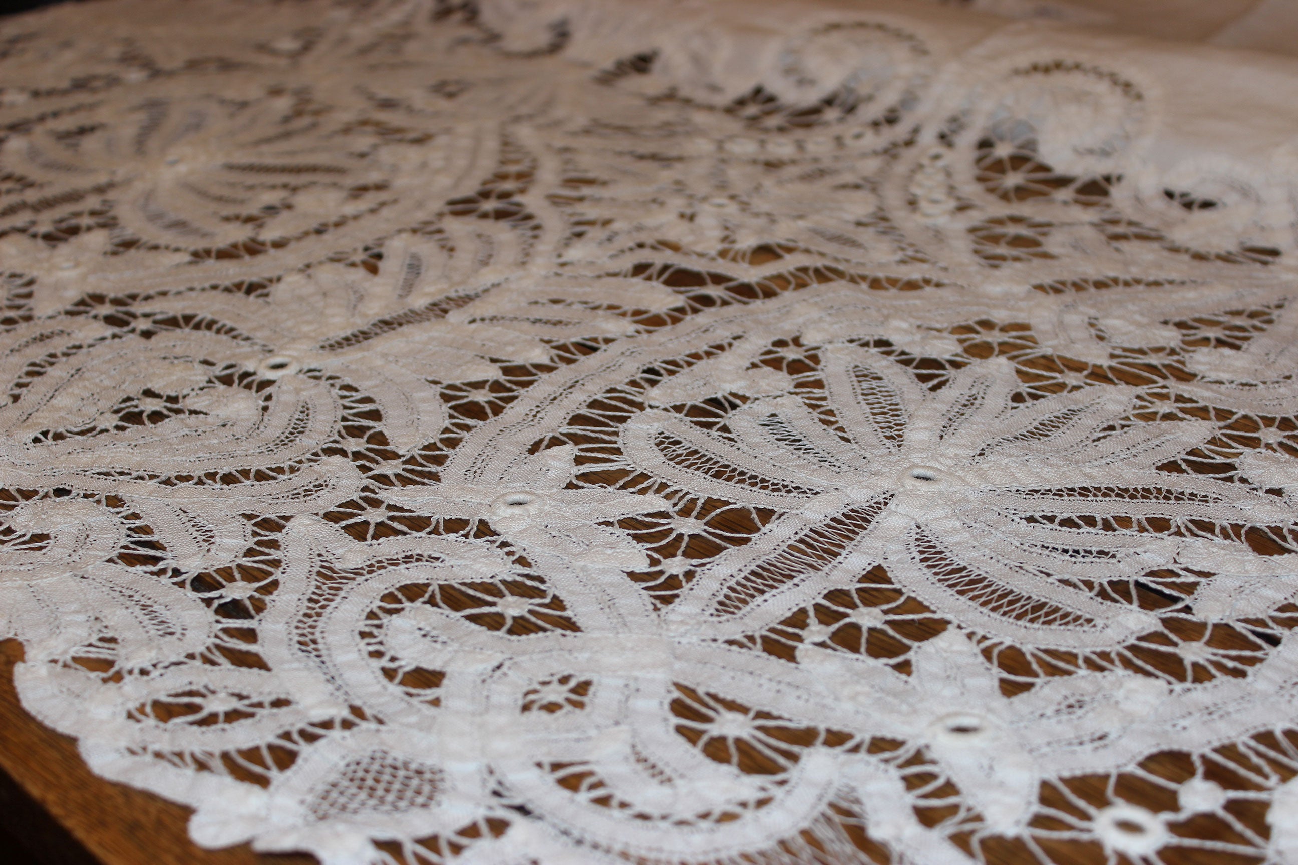 Close-up of intricate lace fabric on a wooden surface