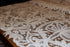 Close-up of intricate lace fabric on a wooden surface
